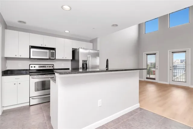 a kitchen with stainless steel appliances a refrigerator stove top oven and sink