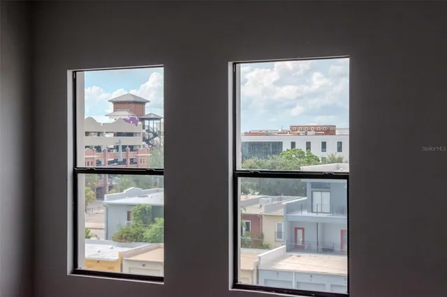 a view of a porch with a floor to ceiling window and potted plants