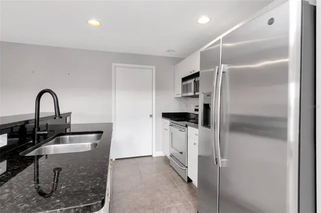 a kitchen with a refrigerator and a sink