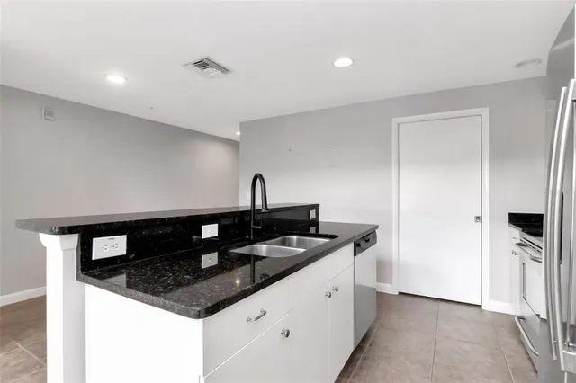 a kitchen with granite countertop a sink and a stove top oven