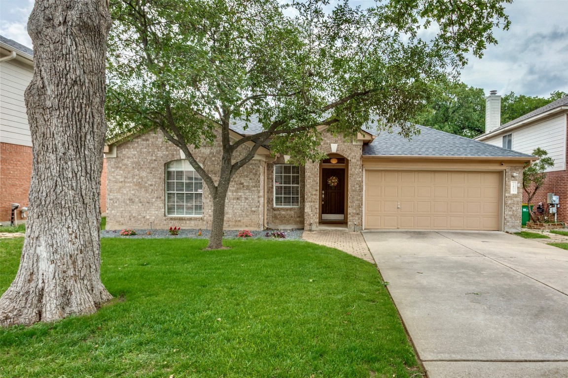 a front view of a house with a garden and yard
