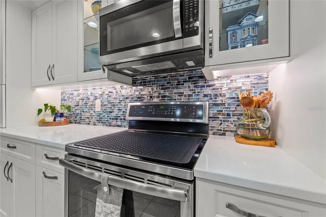 a living room with furniture a flat screen tv and kitchen view