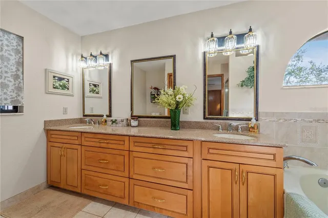 a bathroom with a granite countertop sink mirror and bathtub