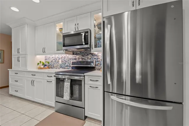 a kitchen with stainless steel appliances a refrigerator sink and microwave