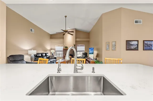 a view of a kitchen with a sink and living room view