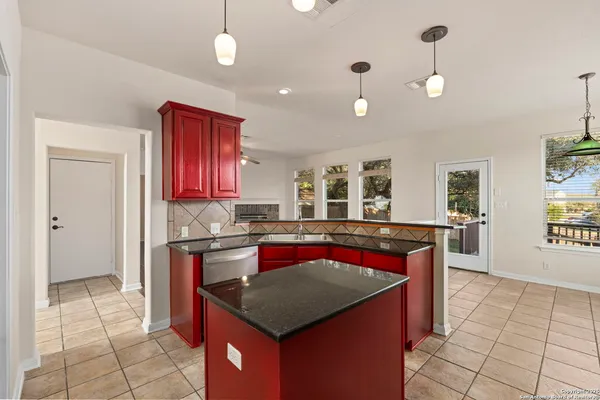 a kitchen with stainless steel appliances granite countertop a stove a sink dishwasher and a refrigerator with wooden floor