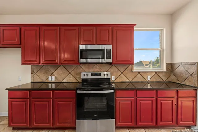 a kitchen with stainless steel appliances granite countertop wooden cabinets and a stove top oven