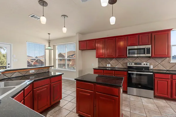 a kitchen with stainless steel appliances granite countertop a stove sink microwave and cabinets
