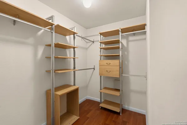 a room with walk in closet and wooden floor