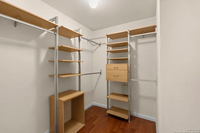 a room with walk in closet and wooden floor