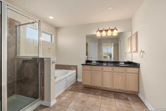 a bathroom with a tub sink and mirror