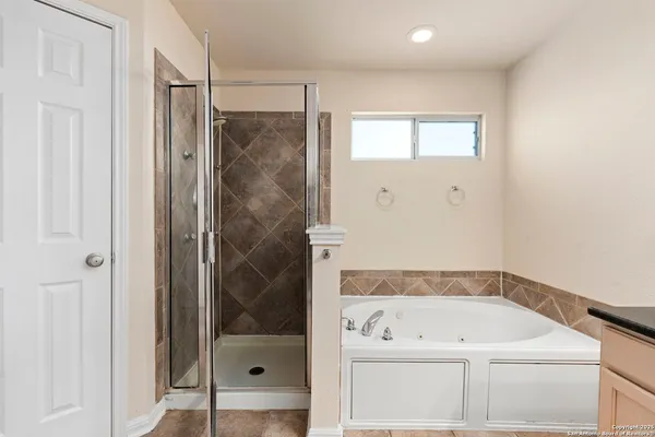 a bathroom with a tub shower and mirror