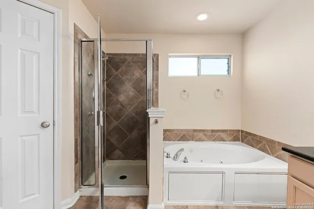 a bathroom with a tub shower and mirror