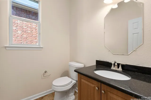 a bathroom with a granite countertop sink and a mirror