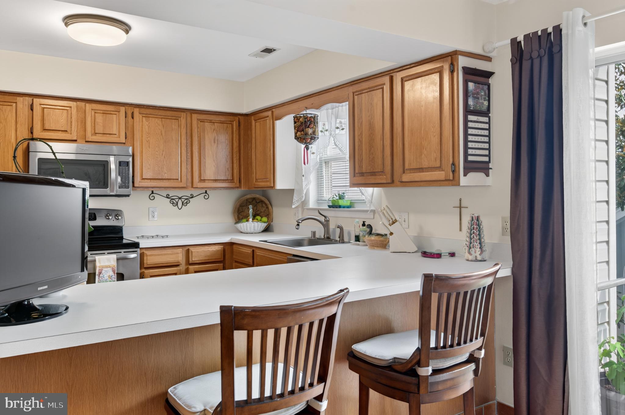 936 Bay Ridge Avenue, Unit 201 Annapolis, MD 21403 - Photo 26 of 40 a kitchen with a sink a window and chairs