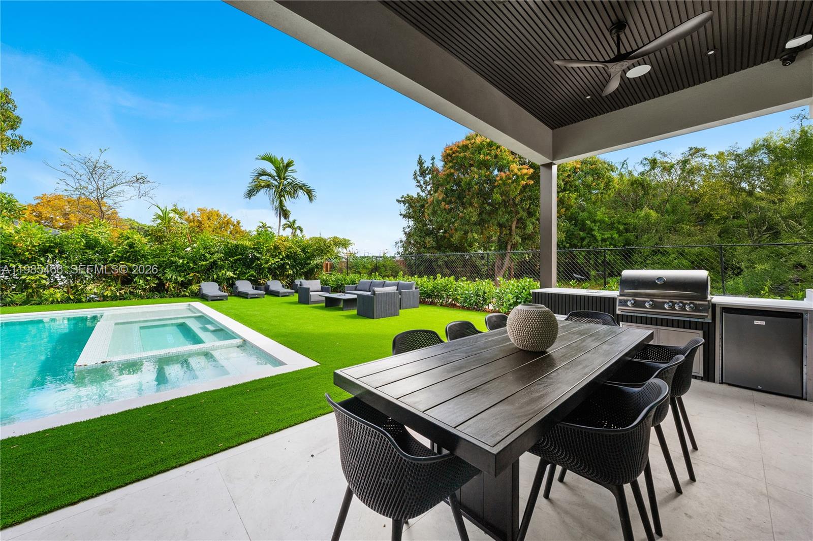 245 Northeast 116th Street Miami, FL 33161 - Photo 11 of 48 a view of a patio with table and chairs under an umbrella with a small yard