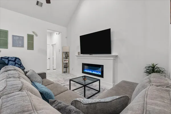 a living room with furniture a fireplace and a flat screen tv