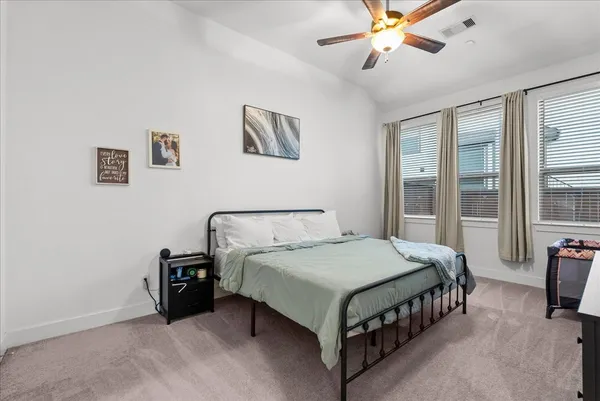 a bedroom with a bed and a flat tv screen on the dresser