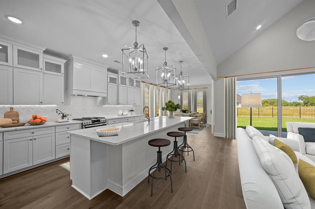 11549 Wulstone Road Fort Worth, TX 76052 - Photo 6 of 35 a open kitchen with granite countertop a stove a sink a dining table and chairs with wooden floor