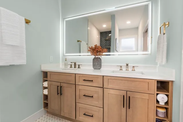 a bathroom with a sink vanity and mirror