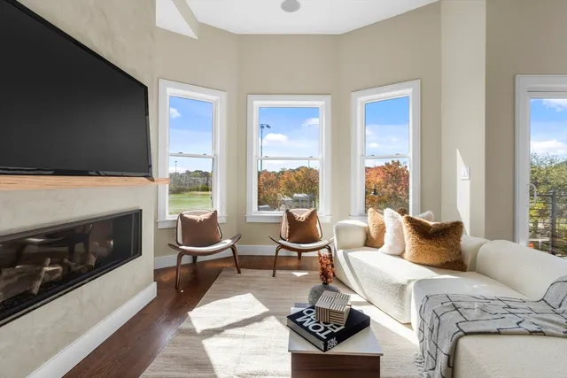 a living room with furniture a flat screen tv and a fireplace