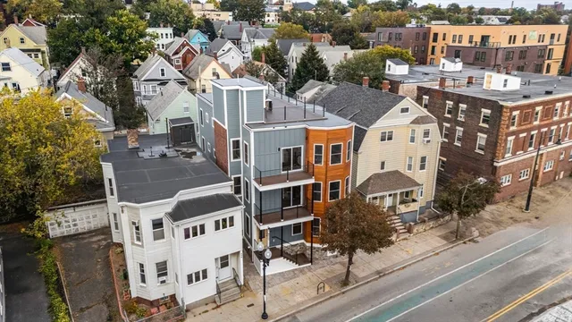a aerial view of a residential apartment building with a yard and parking spaces