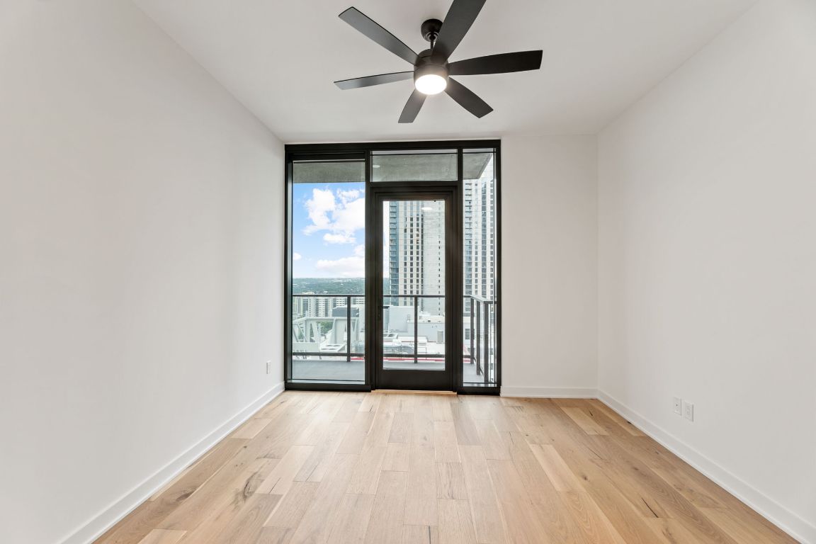 84 East Avenue, Unit 2108 Austin, TX 78701 - Photo 4 of 11 wooden floor in an empty room with a window