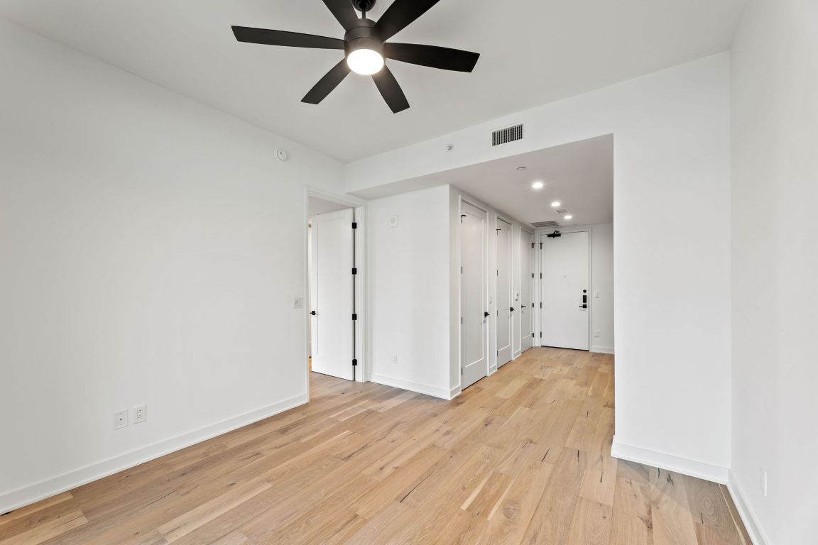 84 East Avenue, Unit 2108 Austin, TX 78701 - Photo 5 of 11 an empty room with wooden floor and windows