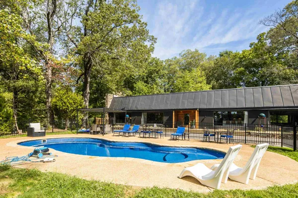 a swimming pool view with a seating space and a garden view