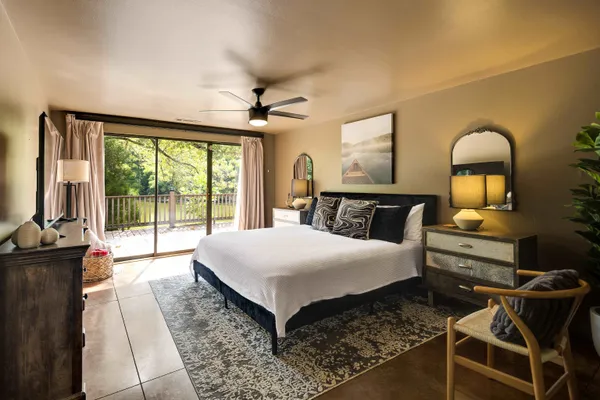 a spacious bedroom with a bed a table and large window