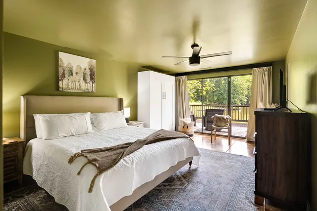 a spacious bedroom with a bed a table and large window