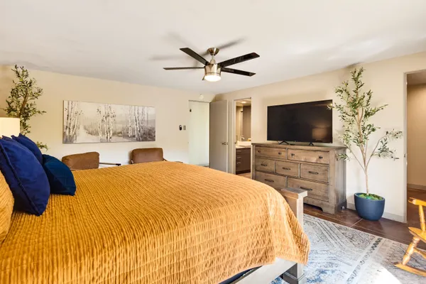 a bedroom with a bed a flat screen tv and a large window with the outer view