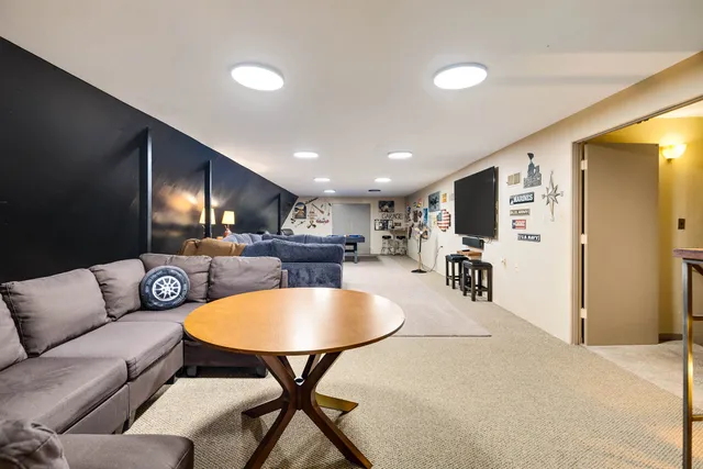 a living room with furniture kitchen view and a wooden floor