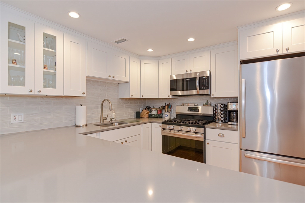 61 Mill Pond, Unit 61 North Andover, MA 01845 - Photo 4 of 31 a kitchen with stainless steel appliances granite countertop a stove top oven a refrigerator a sink and dishwasher