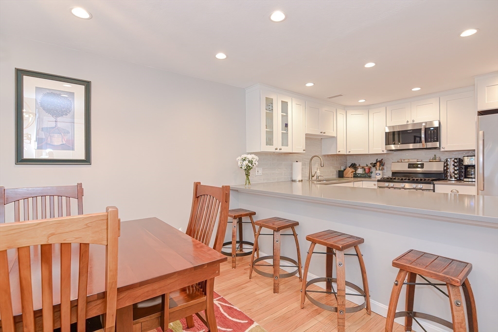 61 Mill Pond, Unit 61 North Andover, MA 01845 - Photo 6 of 31 a kitchen with stainless steel appliances a table and chairs in it