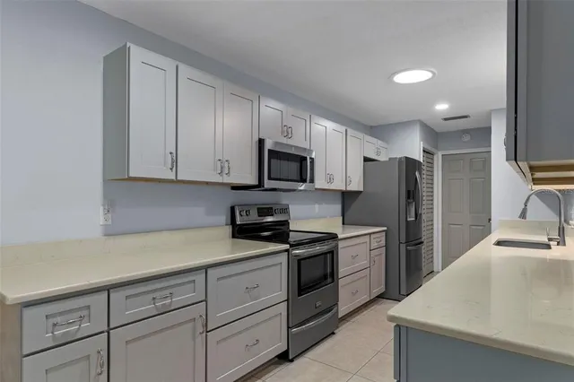 a kitchen with cabinets stainless steel appliances and a sink