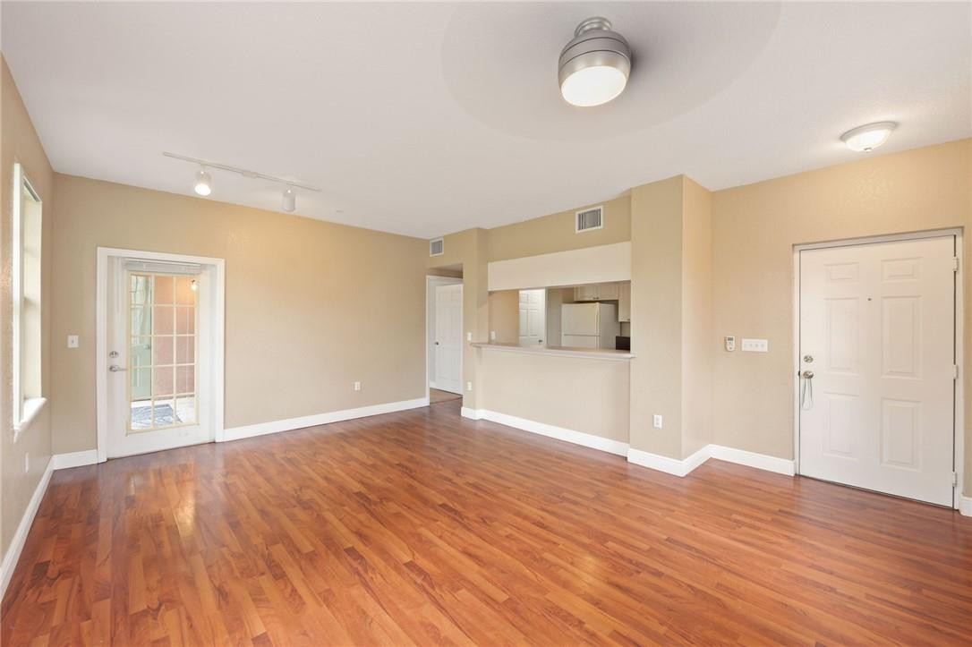 6672 West Sample Road, Unit 6672 Coral Springs, FL 33067 - Photo 8 of 31 a view of an empty room with wooden floor and a window