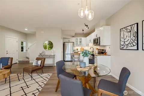 a view of a dining room with furniture a rug and wooden floor
