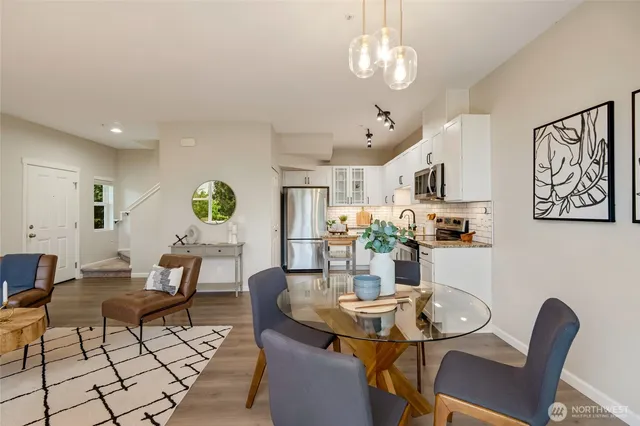 a view of a dining room with furniture a rug and wooden floor