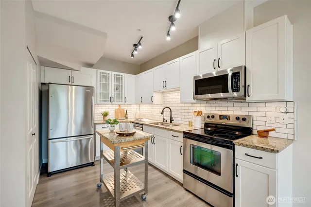 a kitchen with stainless steel appliances a refrigerator stove microwave and sink