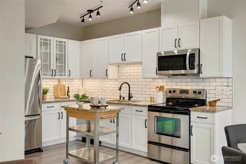 a kitchen with stainless steel appliances a stove sink microwave and refrigerator