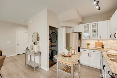 a kitchen with a sink a stove a refrigerator cabinets and dining table