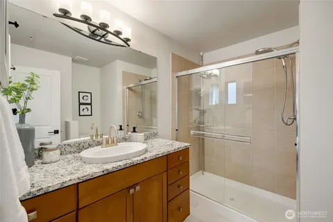 a bathroom with a granite countertop sink mirror and shower