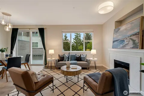 a living room with fireplace furniture and a large window