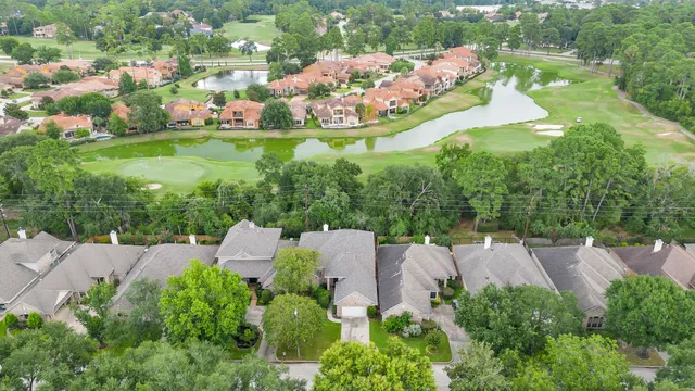 an aerial view of residential houses with outdoor space and trees all around