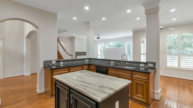 a kitchen with a stove a sink a counter space and a window