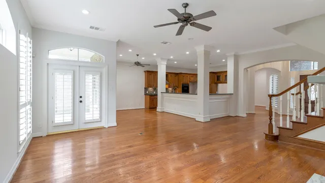 a view of a big room with wooden floor and a kitchen