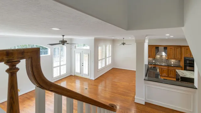 a view of a hallway with wooden floor and staircase