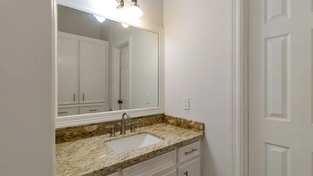 a bathroom with a granite countertop sink and a mirror