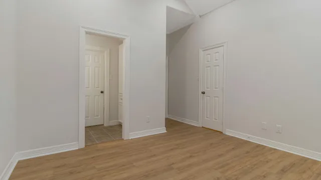a view of an empty room with wooden floor